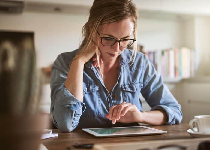 Vrouw kijkt op haar tablet - Ehealth inzetten in GGZ